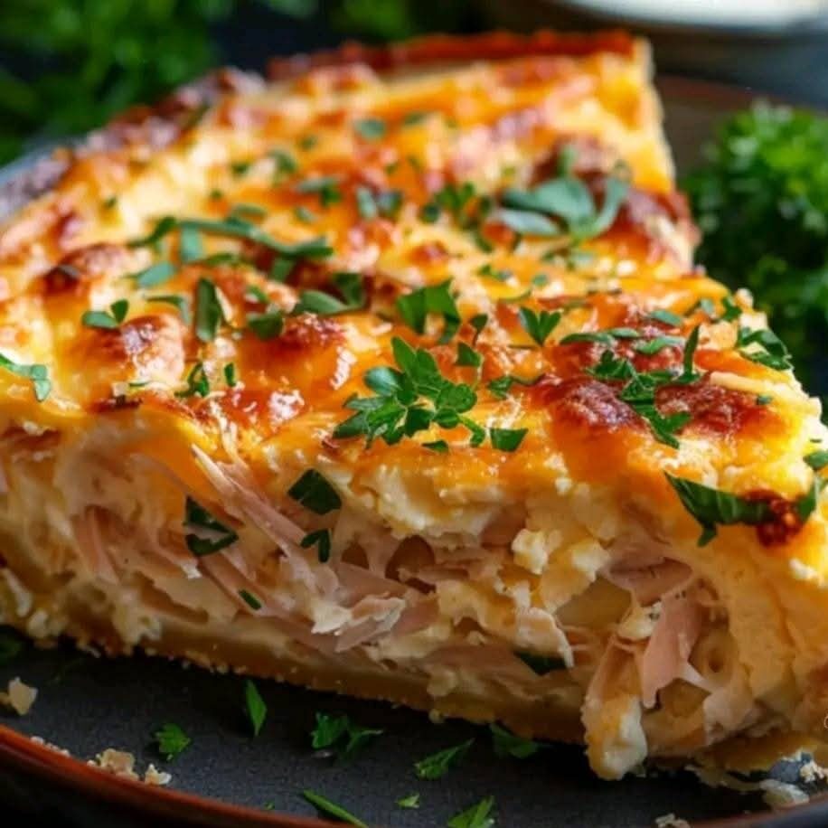 Une quiche au thon dorée et croustillante garnie de persil frais et accompagnée de salade verte.