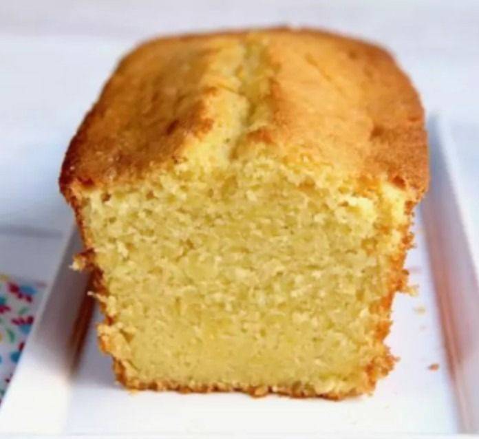 Cake doré au citron et aux amandes, tranché et servi avec une tasse de thé.