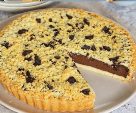 Tarte au chocolat avec une ganache fondante et un crumble doré, servie sur une assiette en céramique