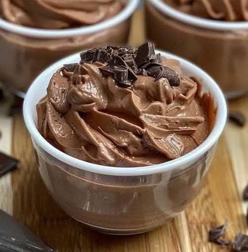 Mousse mascarpone au chocolat servie dans une verrine, saupoudrée de cacao en poudre et décorée de copeaux de chocolat noir